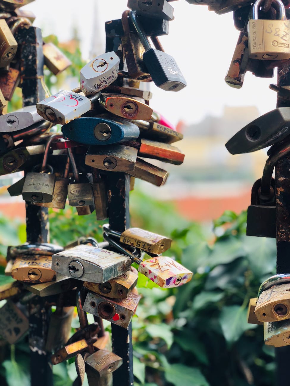 assorted color padlocks locked up in black metal fences