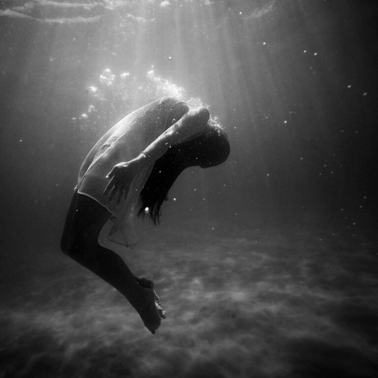 black and white photo of girl underwater