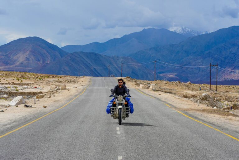 man riding a motorcycle passing by a concrete road